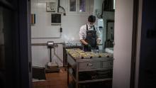 A cook works in Barcelona, ​​Spain on April 16 after his restaurant kitchen is converted to prepare food for health workers and vulnerable people.