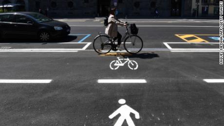 A woman cycles through a bicycle lane in Milan.