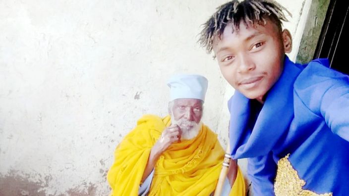 Aba Tilahun's grandson, seen here with his grandfather several years ago, is now looking after him at home
