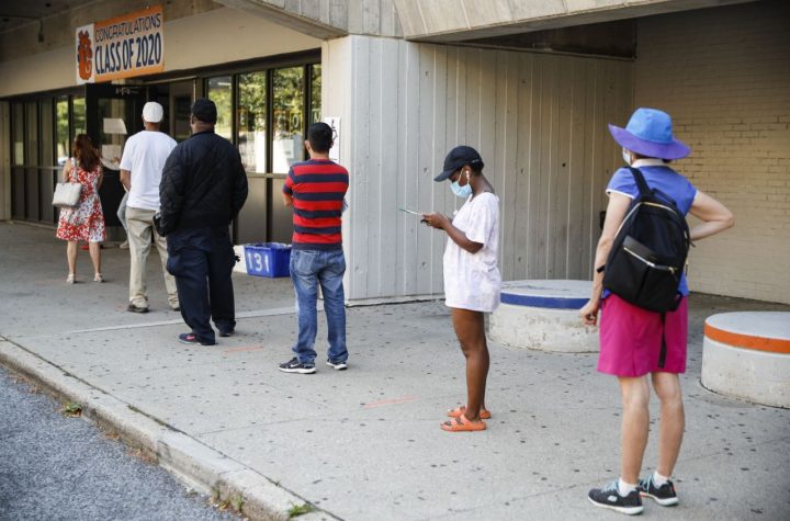 Voters wait in line to cast their ballots in New York's primary election at a polling station inside Yonkers Middle/High School, Tuesday, June 23, 2020, in Yonkers, N.Y. (AP Photo/John Minchillo)
