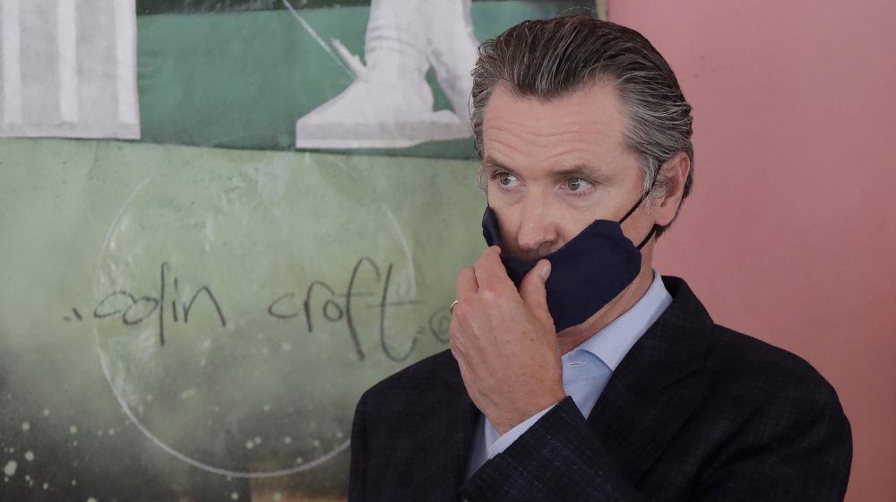 California Governorn Gavin Newsom adjusts his mask while speaking to reporters at Miss Ollie's restaurant amid the coronavirus pandemic in Oakland, California, USA, 09 June 2020. EPA-EFE/JEFF CHIU / A