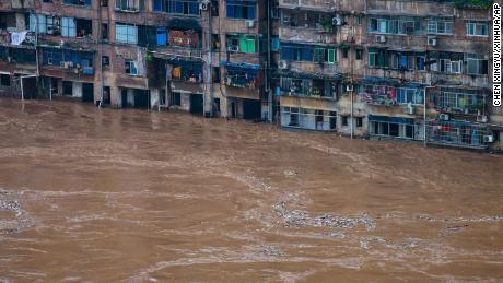 Floodwaters flow past a residential building in Chongqing in southwest China on July 1.