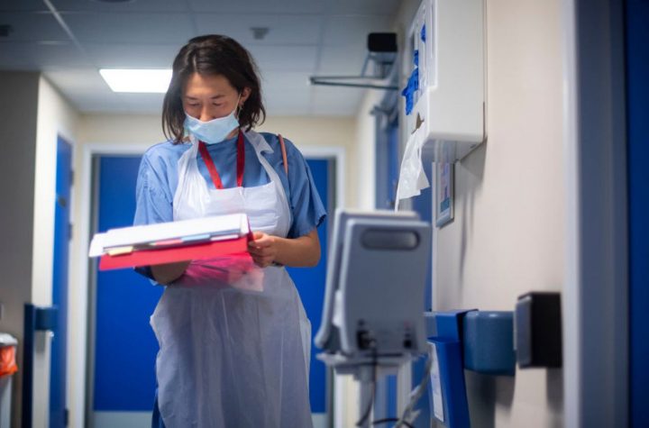 A doctor checks on patients notes at the NHS Seacole Centre in Surrey