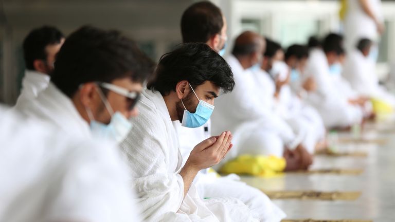 A pilgrim wearing a face mask prays at the Grand Mosque in Mecca