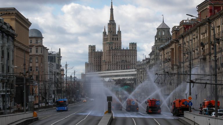 Vehicles spray disinfectant while sanitizing a road in Moscow