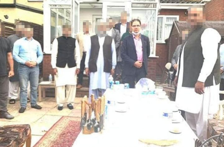 The Mayor of Luton, Tahir Malik, was pictured at the party with his mask hanging below his face