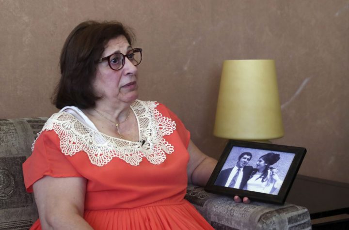 Laure Ghosn, whose husband Charbel Zogheib has been missing for the past 37 years, speaks as she holds their wedding portrait during an interview at her home in Sarba, north of Beirut, Lebanon. Ghosn said her husband is held in Syria and hopes that a new wave of sanctions imposed by the U.S. against the Syrian government will force Damascus to reveal the fate of hundreds of Lebanese citizens held in Syria, including that of her husband. (AP Photo/Bilal Hussein)