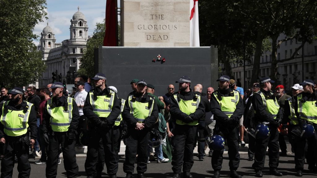 Police form a barrier in front of activists surrounding the Cenotaph