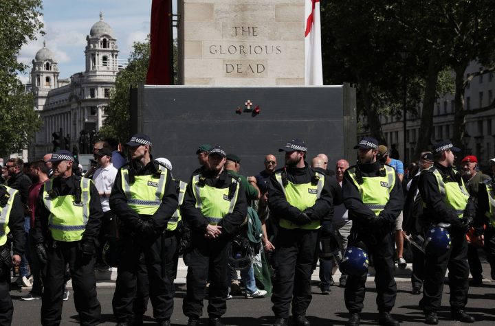 Police form a barrier in front of activists surrounding the Cenotaph