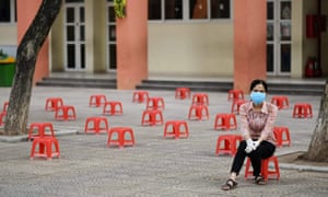 A woman waits at a makeshift rapid testing centre as Vietnam records a rise in coronavirus in Hanoi on 31 July 2020.