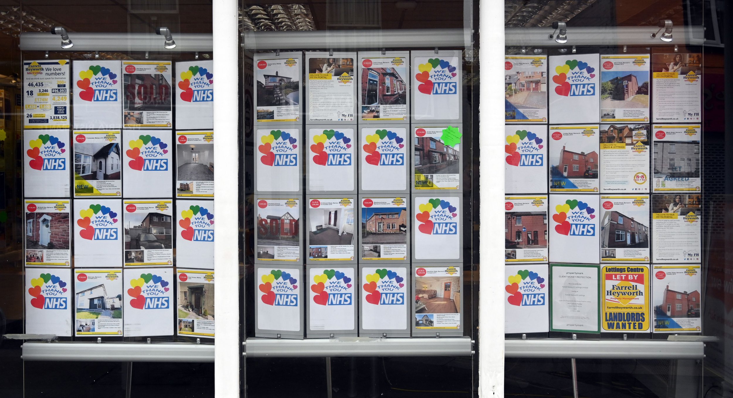 Messages of thanks for the workers of Britain's NHS (National Health Service), are pictured alongside images of houses and residential properties for sale, in the window of an estate agents' shop in Barrow-in-Furness, north west England on May 18, 2020. - As of Monday, Barrow-in-Furness had three times the England and Wales average for the number of coronavirus diagnoses. British health officials added loss of taste and smell to their coronavirus symptoms list on Monday after experts warned cases were being missed. (Photo by PAUL ELLIS / AFP) (Photo by PAUL ELLIS/AFP via Getty Images)