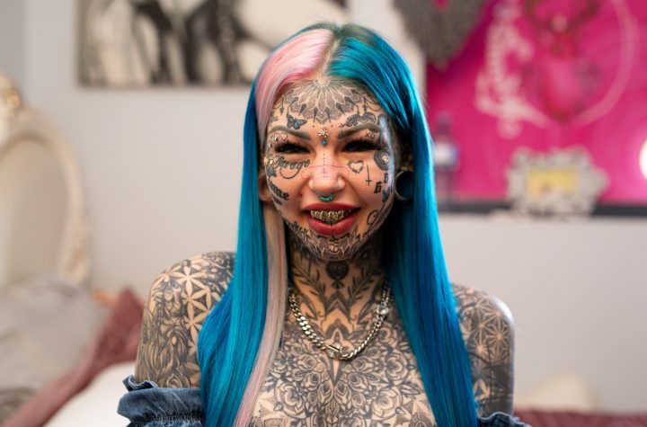 BRISBANE, AUSTRALIA - MAY 28, 2020: AMBER LUKE, 25, from Brisbane, Australia has 600 tattoos covering her face and body. She first filmed with Truly last year, revealing her blue tattooed eyes which blinded her for three weeks. Since then, she has continued to add to her collection with stretched ear lobes, more tattoos, and plans to get a Brazilian Butt Lift. Her journey into body modification began when she was diagnosed with severe clinical depression at 16-years-old. She explained the reasons behind her extreme look to Truly: "I know it sounds very materialistic that I want to change myself but imagine hating yourself so much that you couldn't even look in a mirror or step outside your house. It was just, it was a horrific way to live." Amber has now spent $50,000 on tattoos, and $70,000 overall on body modifications. She joked that the high cost makes her mum cry, but Amber doesn't "plan on stopping anytime soon". Her next procedure will be a Brazilian Butt Lift, which she has gained 10 kilos for, as the fat will be injected into her butt. She said: "A lot of people will give me scrutiny for this because, you know, 'Why not just go to the gym'?" Amber continued: "I'm lazy, I'd rather pay the 15 grand." Now she feels much more content and has been with her partner Sam for six months. "He is absolutely amazing," she said. "There's not anything that I do or say that scares him away." PHOTOGRAPH BY Joshua Maguire / Barcroft Studios / Future Publishing - NOTE: This Photo Can Only Be Used Within Context With The Information Provided In The Metadata (Photo credit should read Joshua Maguire/Barcroft Media via Getty Images)