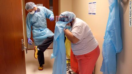 Dr. Drew Miller sprayed disinfectant on his shoes, while respiratory therapist Jade Carabazel-Richter removed the protective gear at Kirney County Hospital in Locken, Kansas.