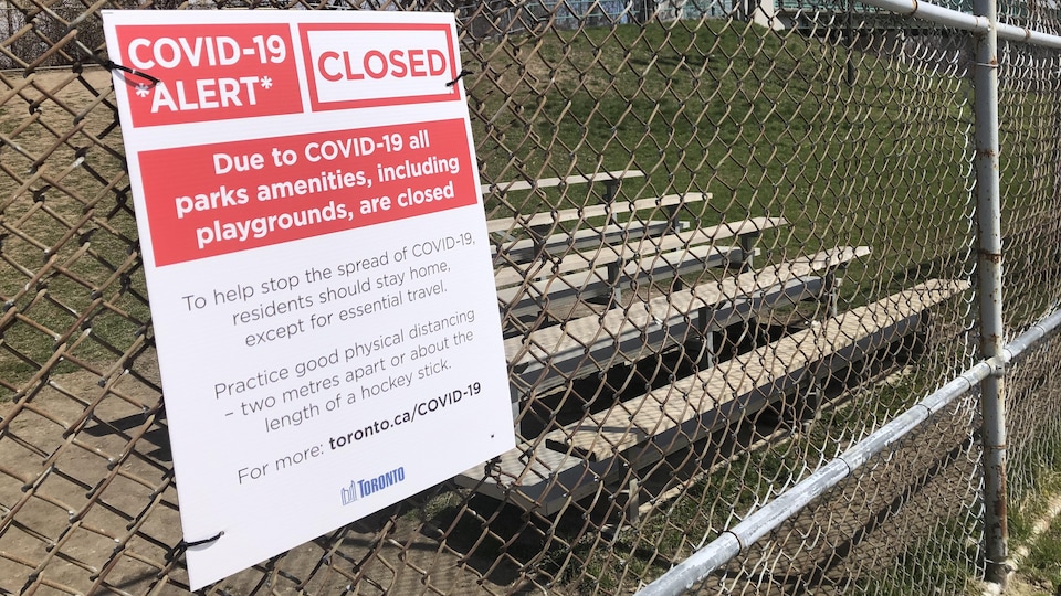 Notice of closure of park facilities affixed to the fence of the baseball field.