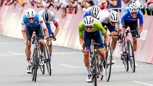 Un cycliste célèbre sa victoire après avoir traversé le fil d'arrivée