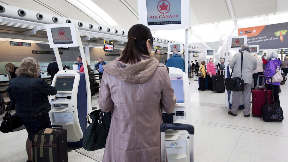 Passengers check in at the kiosk.