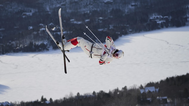 Un skieur acrobatique fait un saut dans les airs.