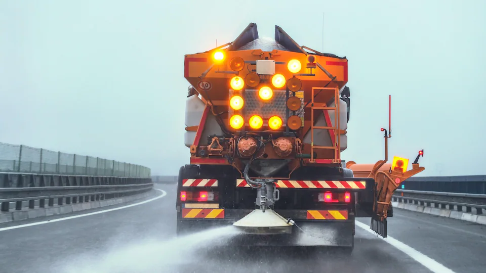 A truck spreads salt on the road.