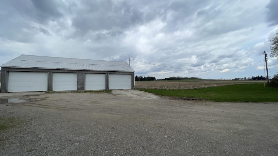 A garage in front of the farm land.