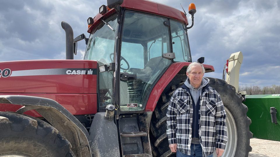 Smiling farmer in front of his tractor.