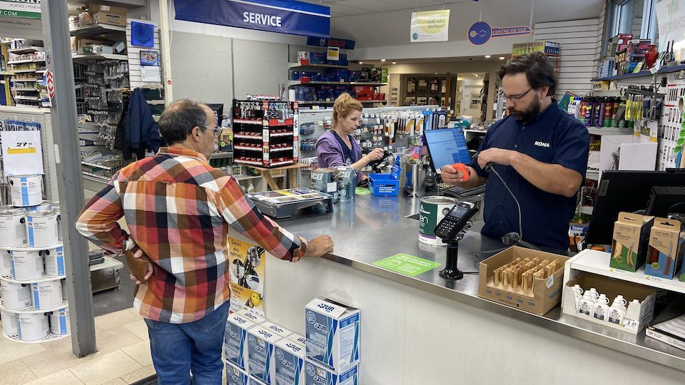 A cashier at a hardware store in the middle of a transaction.