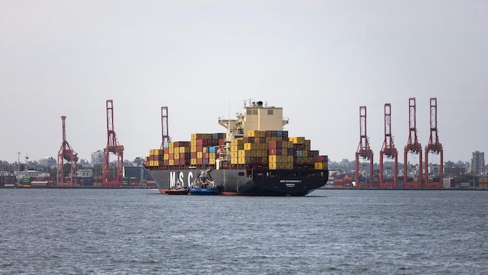 A ship full of containers is docked in the port of Vancouver.