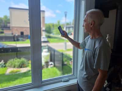 Jose Legris is behind his Net Zero house in Mascouche, where you can see the solar panels on the roof.