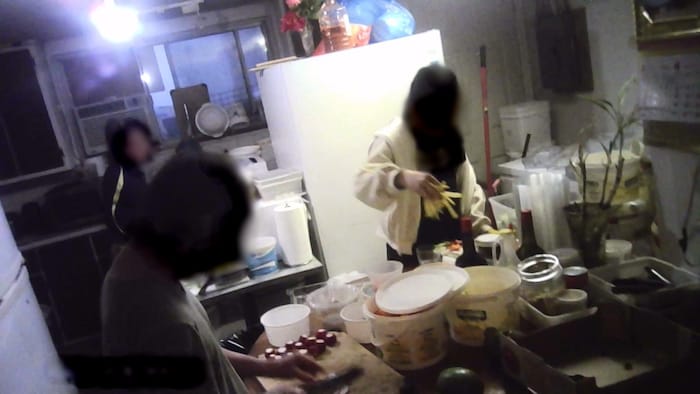 A woman, a teenage girl and a man prepare sushi in an improvised kitchen.