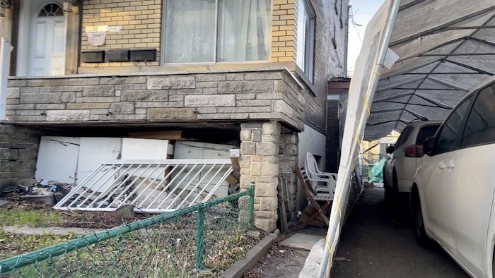 Facade of a residential building, furniture scattered on the floor.