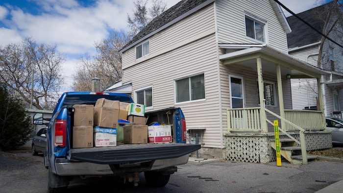 A van carrying boxes stops near a house.