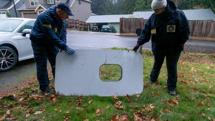 At the residence, a man and woman wearing US Transportation Safety Agency coats hold the plane's door.