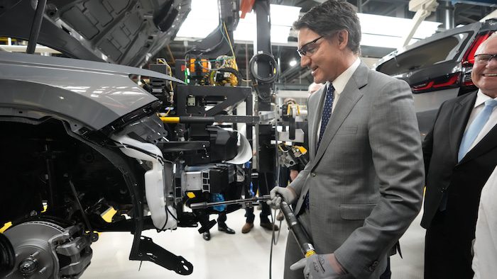 Justin Trudeau screws a bolt at the Honda plant in Alliston during a press briefing on April 25, 2024.