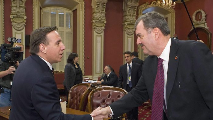 MM.  Rousseau and Legault shaking hands at the Salon Rouge.